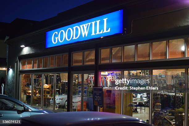 Goodwill retail store front in the Capitol Hill neighborhood of Seattle, Washington. Cars are parked outside and thrift goods are seen through the...
