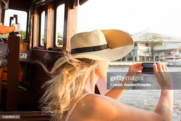 pic に女性がスマートフォンで、リバーボート - hot women on boats ストックフォトと画像