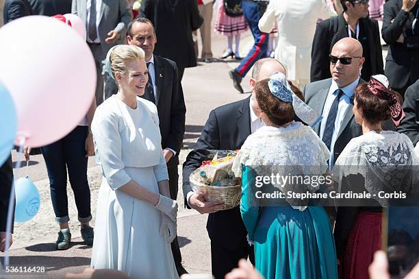 Princess Charlene of Monaco and Prince Albert II of Monaco greet people on the Monaco Palace square after the baptism of the Princely Children in...