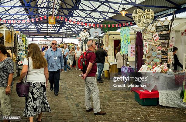 people looking at stalls inside greenwich market, london - craft show stock pictures, royalty-free photos & images