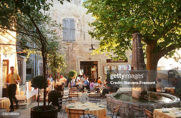 people relaxing on a restaurant terrace - provence village fotografías e imágenes de stock