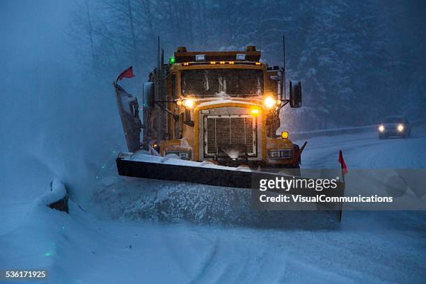 snowplow plowing the highway during snow storm. - sneeuwschuiver stockfoto's en -beelden