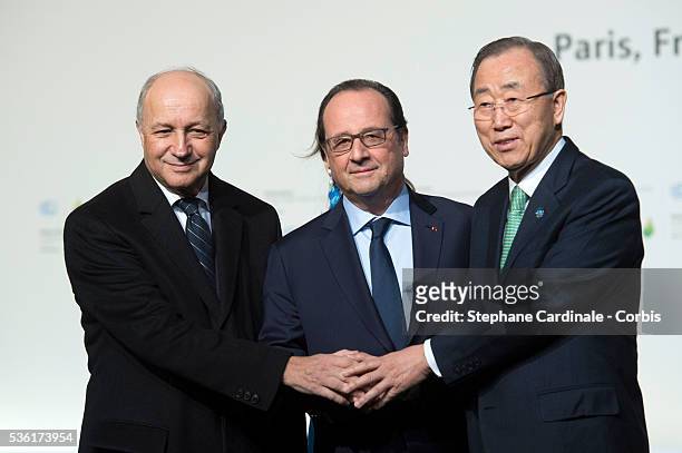 French Foreign Affairs Minister Laurent Fabius, French President Francois Hollande and United Nations Secretary General Ban Ki-moon shake hands as...