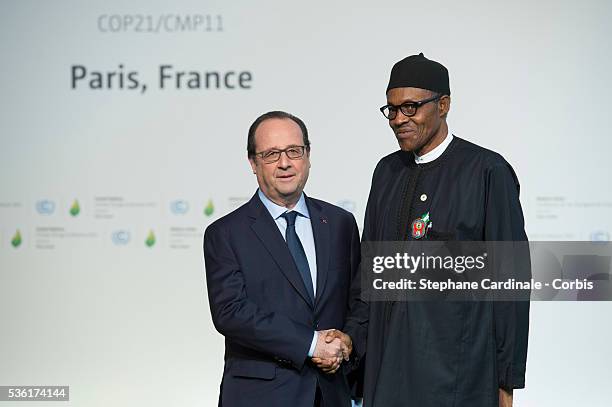 Nigerian President Muhammadu Buhari shakes hands with French President Francois Hollande, upon his arrival for the COP21 United Nations Climate...