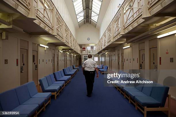 Female prison officer walks through the communal area inside one of the residential wings. HM Prison Styal is a Closed Category prison for female...