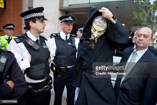 Julian Assange at the Occupy London demonstration 15th October 2011. Seen here after arriving in a taxi with his own security, he tries to get...