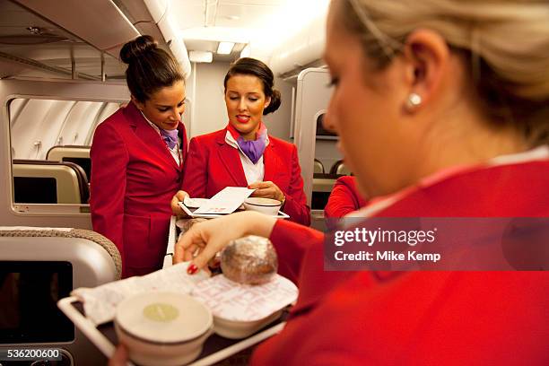One week away from getting their 'wings' these flight attendants proudly wear their red uniforms as they undergo an in flight training session...