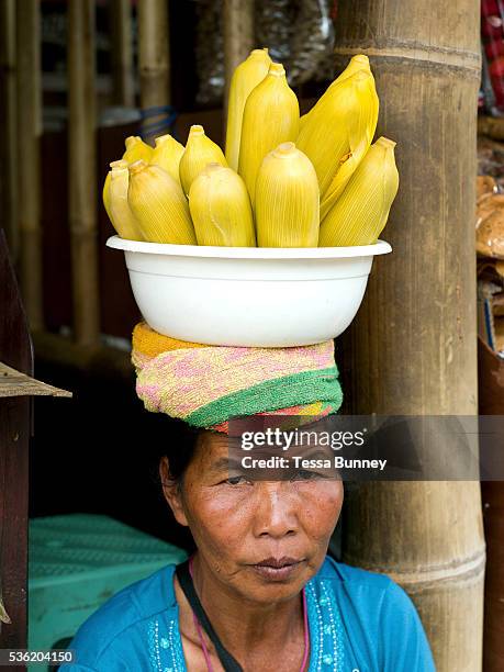 Woman selling corn from a bowl resting on her head, Bedugal market, Bali, Indonesia