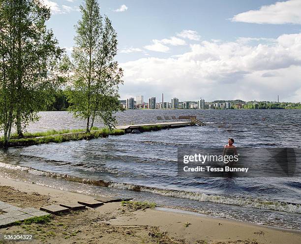 After taking a sauna, a woman returns from a swim in Lake Jyvasjarvi, Jyvaskyla, Central Finland. Jyvaskyla is the capital of Central Finland and the...