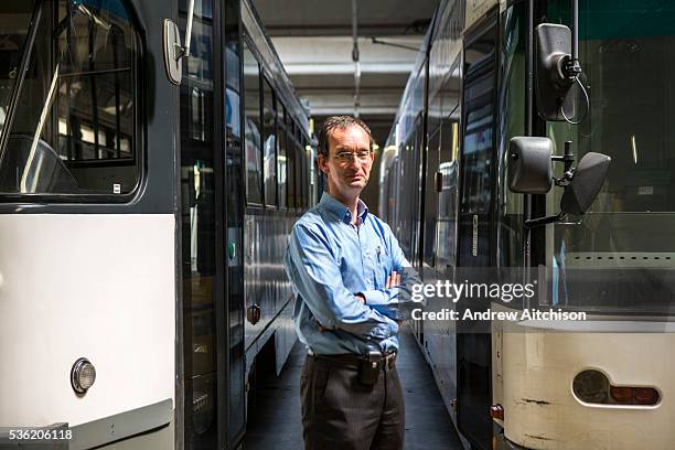 Portrait of Patrick De Boeuf, Chief Executive of De Lijn proudly stands in front of two modern electric public transport trams in Gentbrugge, Ghent,...