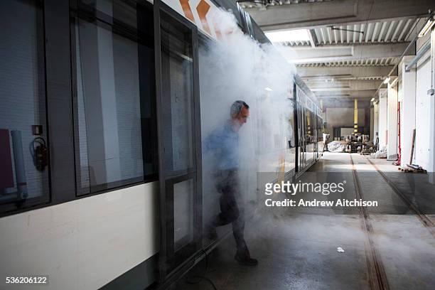 Patrick De Boeuf, Chief Executive of De Lijn, steps off an electric tram surrounded with white smoke in the tram depot in Ghent, Belgium. He is...