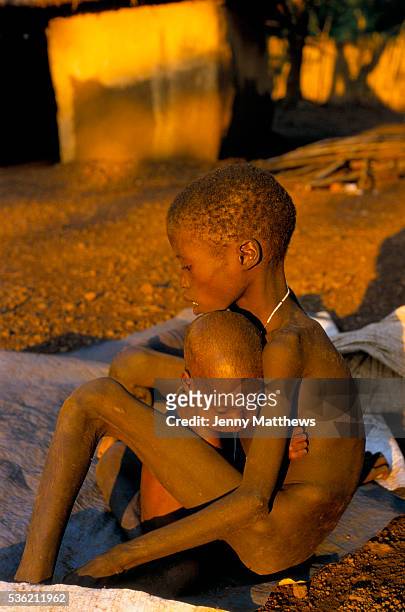 Baby clings to his malnourished brother at an aid agency feeding centre. Ajiep, Bahr el Ghazal, Sudan. The famine in Sudan in 1998 was a humanitarian...