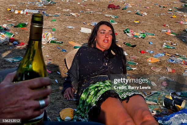 Girl lying in the debris of the morning after in the HUB, The centre of Shangri-La, Glastonbury Festival 2010