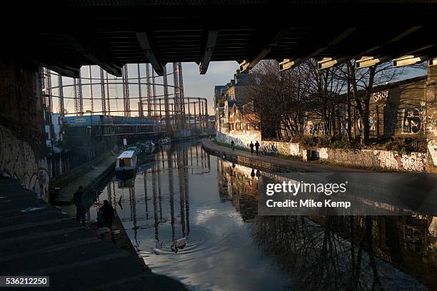 Evening light under a railway bridge over Regents Canal in Hackney, London, England, UK. A beautiful urban scene of calm in the East End. Old...