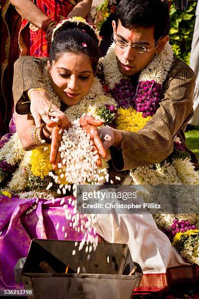 At a Hindu wedding ceremony, bride Shweta Singhal and groom Rohit clasp each others hands with a handful of puffed rice which is then thrown into a...