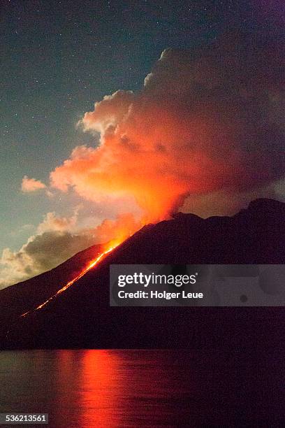 stromboli volcano with lava flow at night - vulkan stock-fotos und bilder