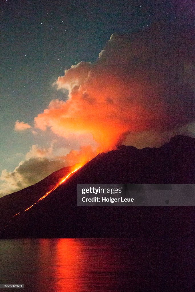 Stromboli volcano with lava flow at night