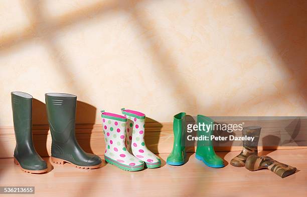 green family boots in a line - family shoes stock-fotos und bilder