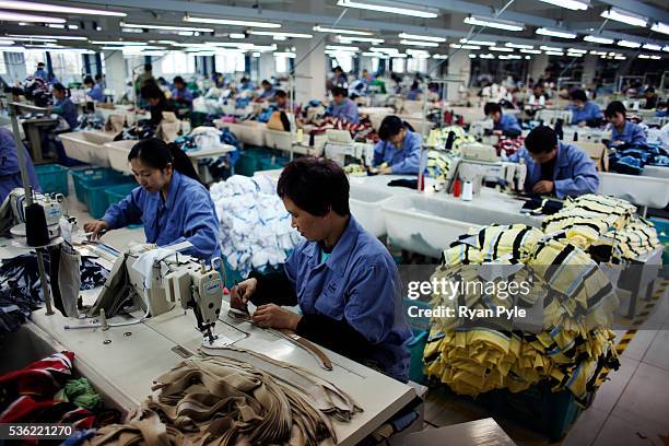 Women work at the Seven Iris Textile Factory in Shaoxing, Zhejiang Province, China. Shaoxing is China's home to the textile industry and the...