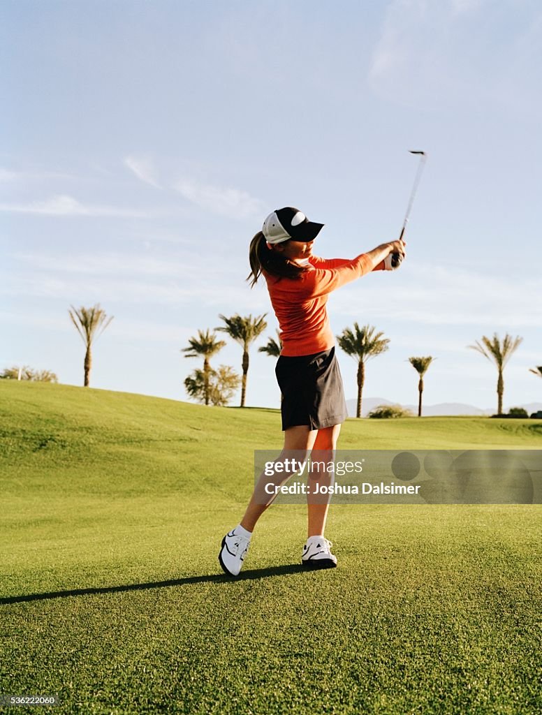 Golfer swinging golf club