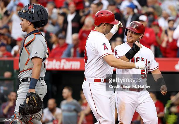 Cron of the Los Angeles Angels of Anaheim is congratulated by Kole Calhoun after hitting a two-run home run as James McCann of the Detroit Tigers...