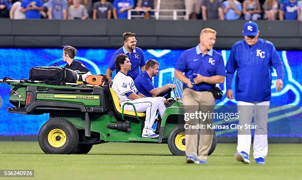 The Kansas City Royals' Brett Eibner leaves the field in a cart as head trainer Nick Kenney and manager Ned Yost walk off the field in the fifth...