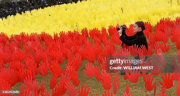 Jane Powles, national campaign manager for ANTAR, places hands in a huge art installation called 'Sea of Hands' which consists of thousands of hands...