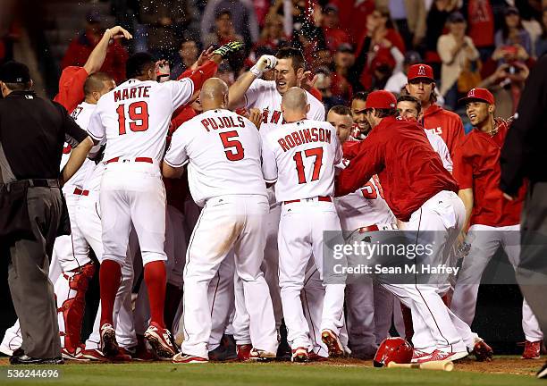 Jefry Marte, Albert Pujols, Shane Robinson, congratulate C.J. Cron of the Los Angeles Angels of Anaheim at home plate after Cron hit a walk off...