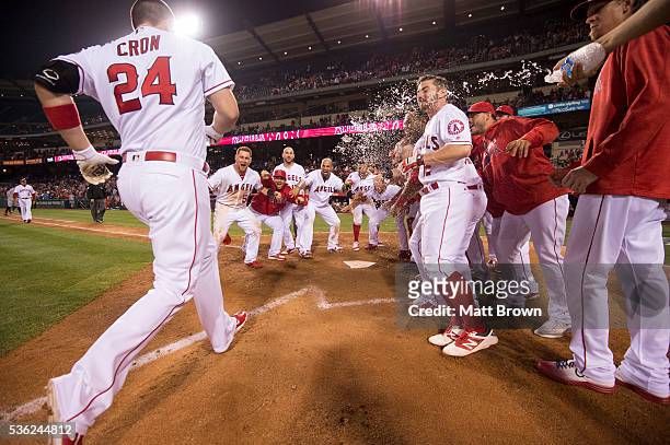 Cron of the Los Angeles Angels of Anaheim is greeted at home plate by his teammates after hitting a walk-off two-run home run to defeat Detroit...