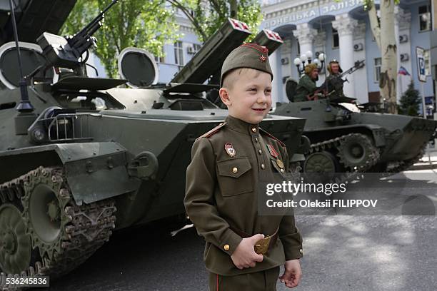 This photo taken on May 5, 2016 shows a boy wearing a Soviet-era uniform standing in front of an APC during rehearsal of Victory Day parade in...
