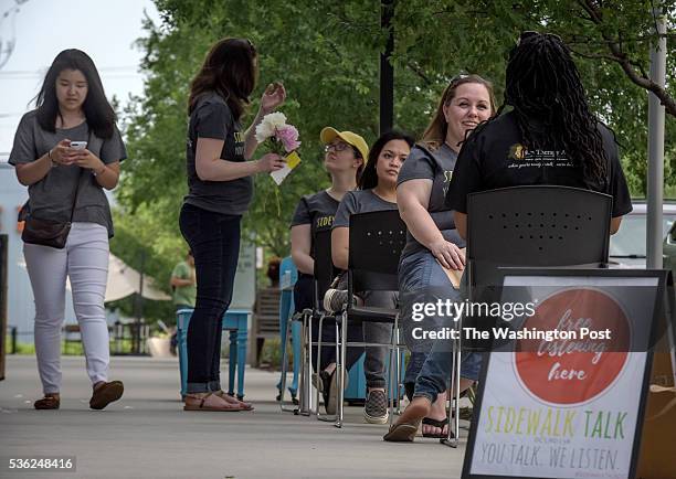 Volunteers with Sidewalk Talk DC, a free listening project and community service, sit patiently waiting to entice passersby to have a non digital...