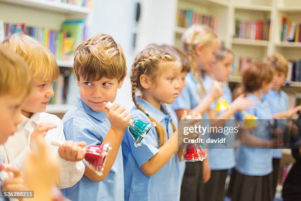 musical bells being played by school children - school bell stock pictures, royalty-free photos & images