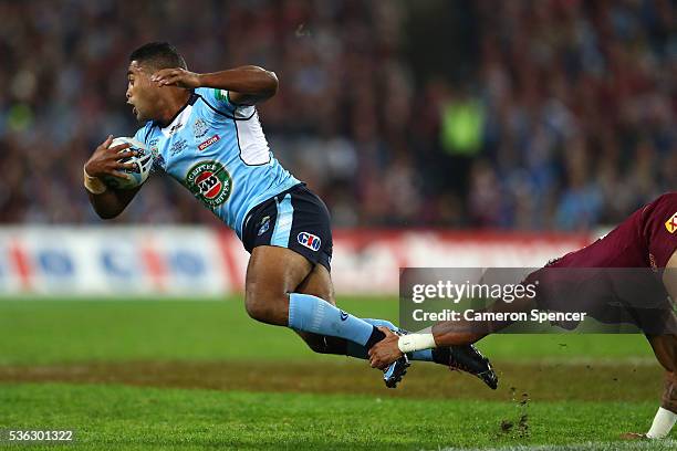 Michael Jennings of the Blues is tackled during game one of the State Of Origin series between the New South Wales Blues and the Queensland Maroons...