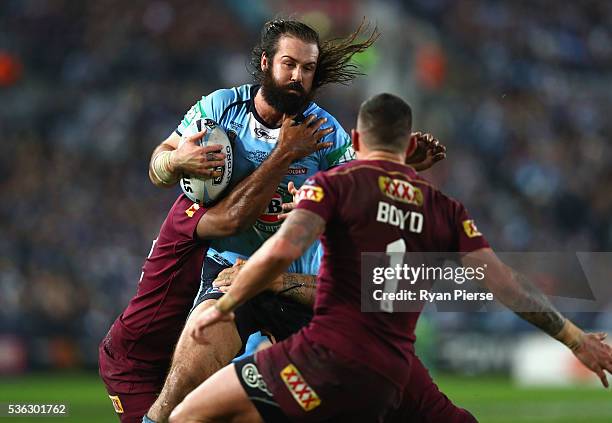 Aaron Woods of the Blues is tacked during game one of the State Of Origin series between the New South Wales Blues and the Queensland Maroons at ANZ...