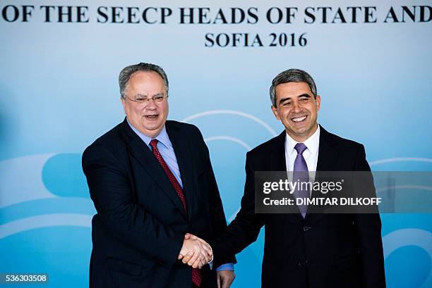 Bulgarian President Rosen Plevneliev shakes hands with Greece's Foreign Minister Nikolaos Kotzias prior to the Summit of the Cooperation Process in...