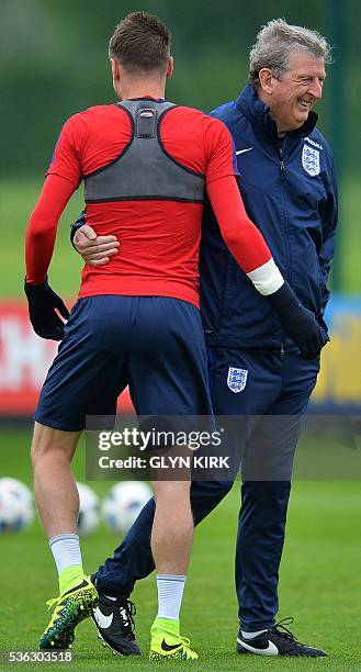 England's manager Roy Hodgson reacts after talking with England's striker Jamie Vardy during a team training session in Watford, north of London, on...