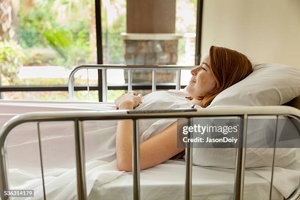 cute young teenager smilling in a hospital bed - railing stock pictures, royalty-free photos & images