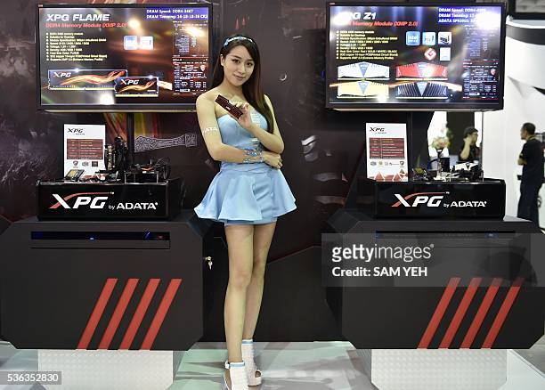 Promotional model poses with video game products during the annual Computex computer show in Taipei on June 1, 2016. More than 5,000 booth...