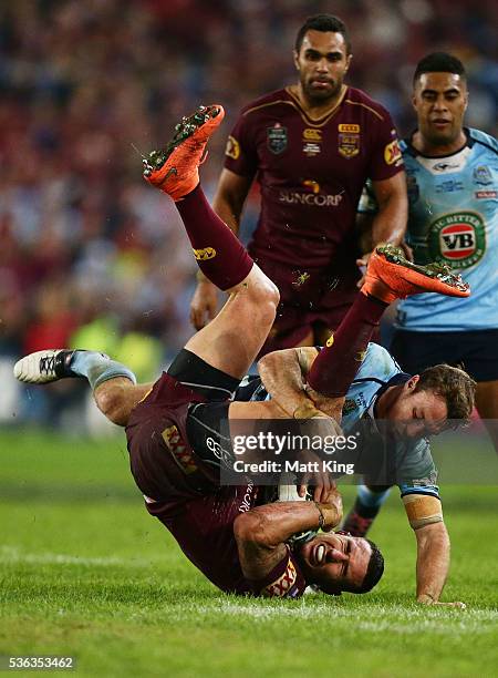 Darius Boyd of the Maroons is tackled by James Maloney of the Blues during game one of the State Of Origin series between the New South Wales Blues...