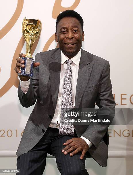 Pele with a replica Jules Rimet trophy attends a photocall for the Pele: THE COLLECTION at Julien Auctions on June 1, 2016 in London, England