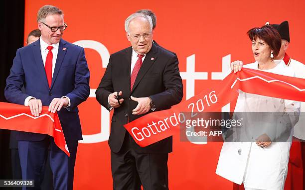 Swiss President Johann Schneider-Ammann cuts the ribbon next to Swiss Federal Railways CEO Andreas Meyer and Swiss Transport Minister Doris Leuthard...