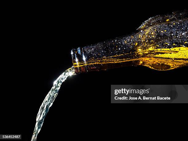 bottle with a jet of fresh beer - beer flowing stock pictures, royalty-free photos & images