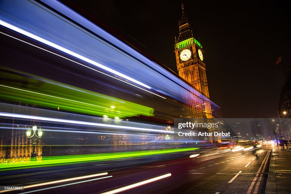Green Big Ben at night with bus light trail London