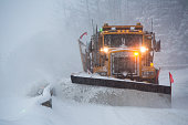 Snowplow plowing the highway during snow storm.