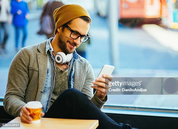 man typing text message - young man blue eyes stock pictures, royalty-free photos & images