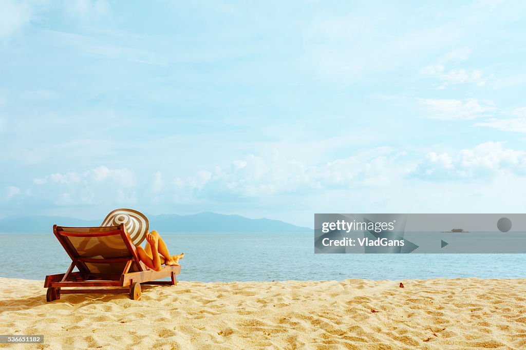 Woman sunbathing in beach chair
