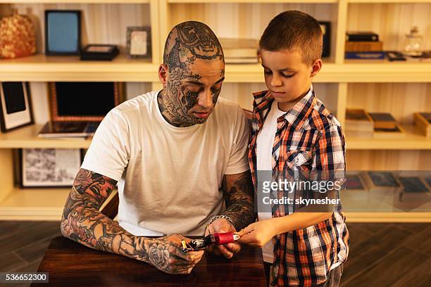 Father Showing Son How To Use Tattoo Gun At Home High-Res Stock Photo -  Getty Images