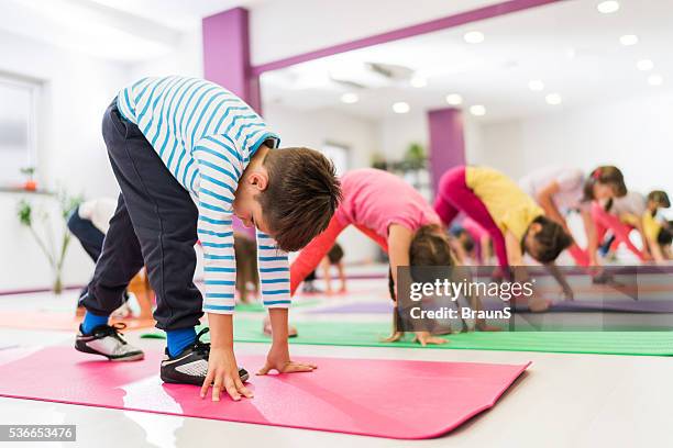 group of kids stretching their legs on a sports training. - buigen lichaamsbeweging stockfoto's en -beelden
