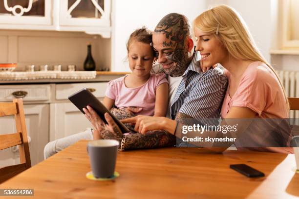 smiling parents surfing the internet with daughter on touchpad. - kids learning at home stock pictures, royalty-free photos & images