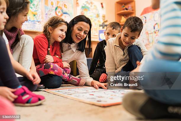 glückliche kinder lehrerin erziehung großen eine gruppe von kinder bereits im kindergarten. - lehrtätigkeit stock-fotos und bilder